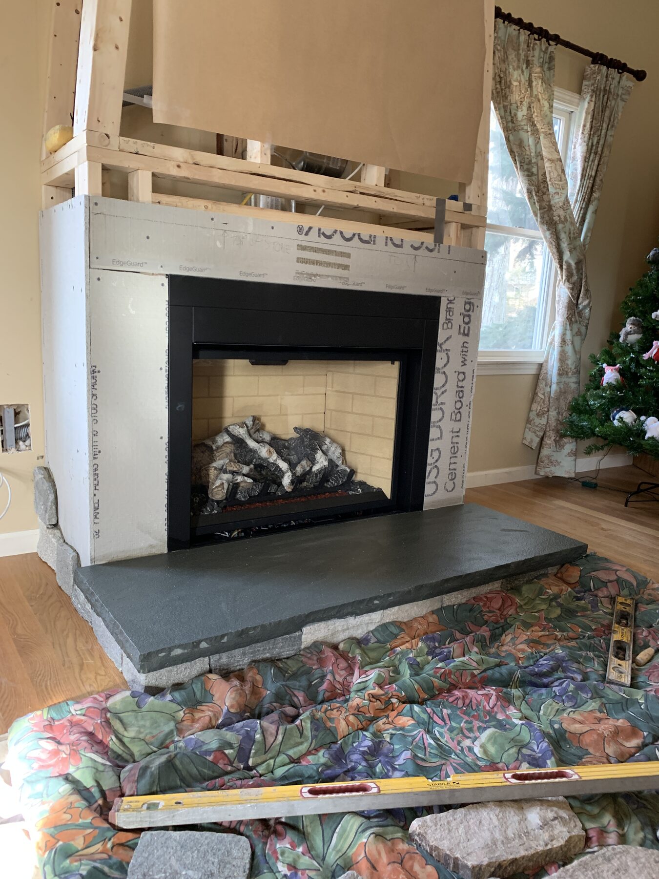 Rough frame with cement board ready for stone veneer around a gas insert fireplace