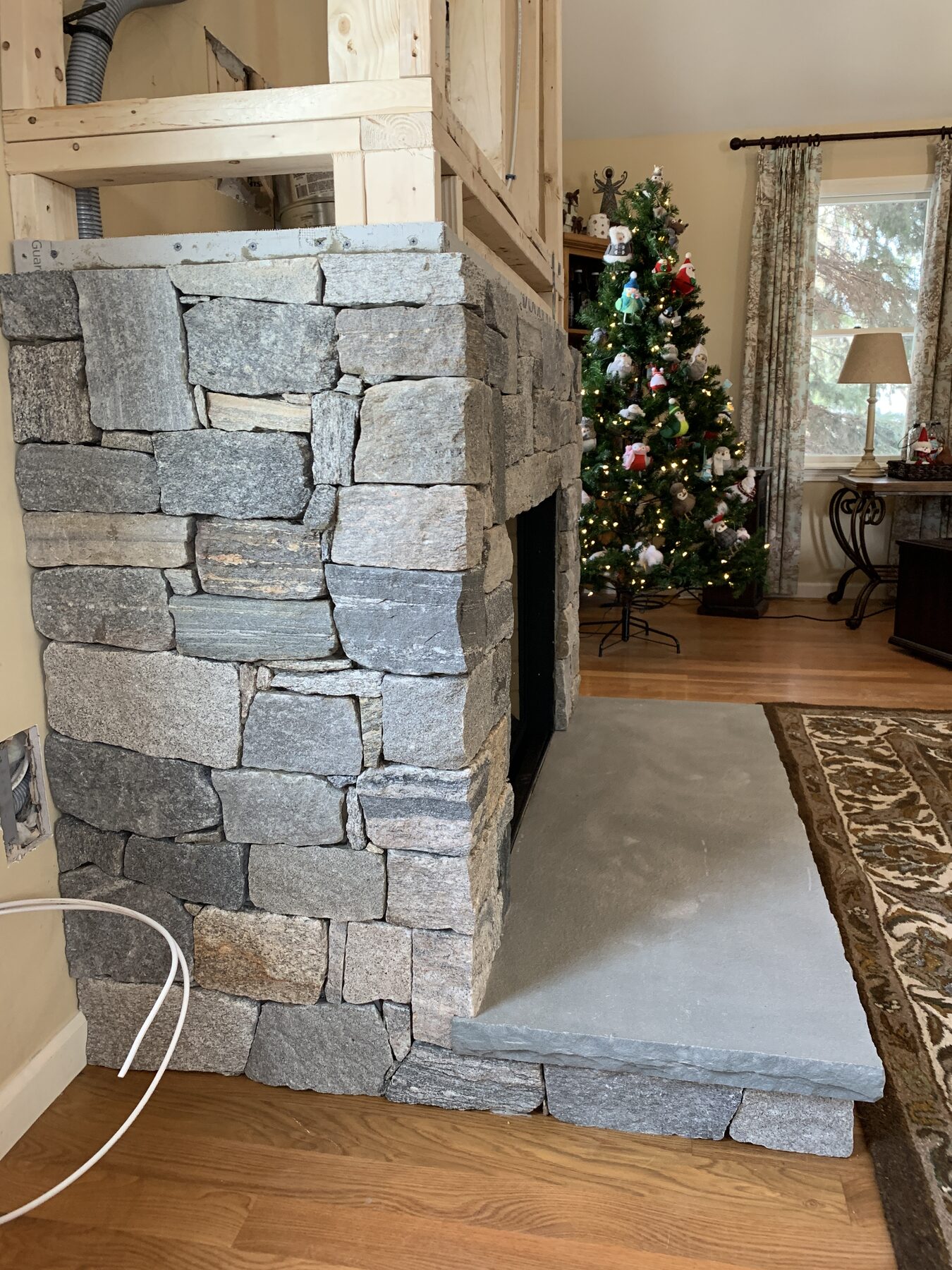 Stone veneer underway around the new construction gas insert fireplace