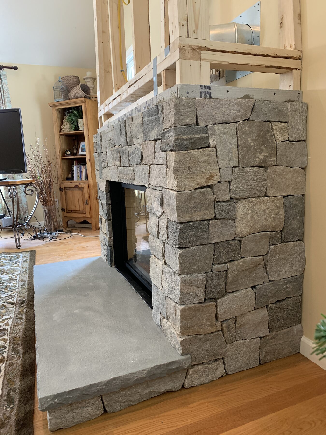 Stone veneer built higher around the fireplace opening